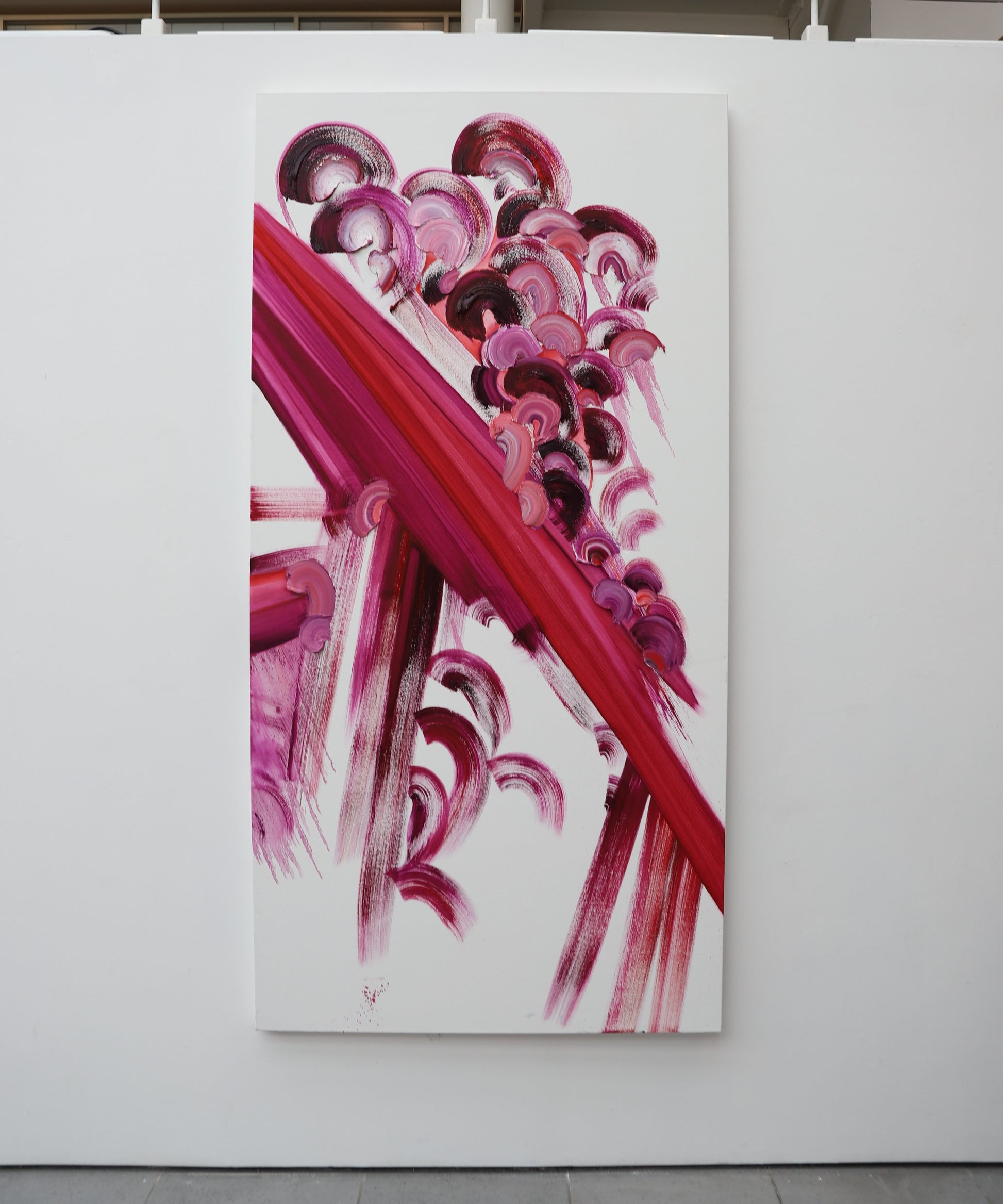 Abstract painting with pink and red brushstrokes on a white background