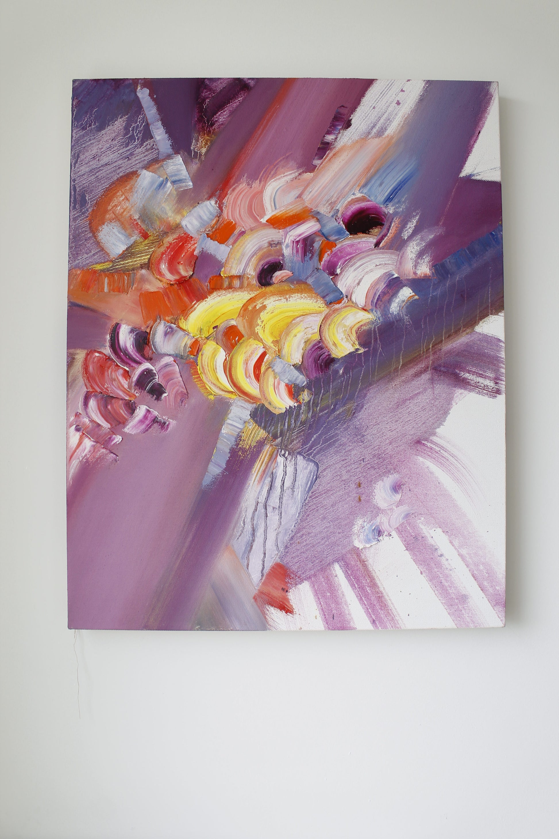 Abstract painting with vibrant colors on a white wall